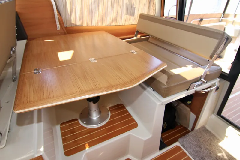  Yacht Photos Pics Interior dining area of 2020 Ranger Tugs R-29 with wooden table and cushioned seating.