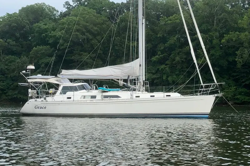 Starlight Yacht Photos Pics Sailboat "Grace" on water, 2016 Outbound 46 model, surrounded by lush greenery.