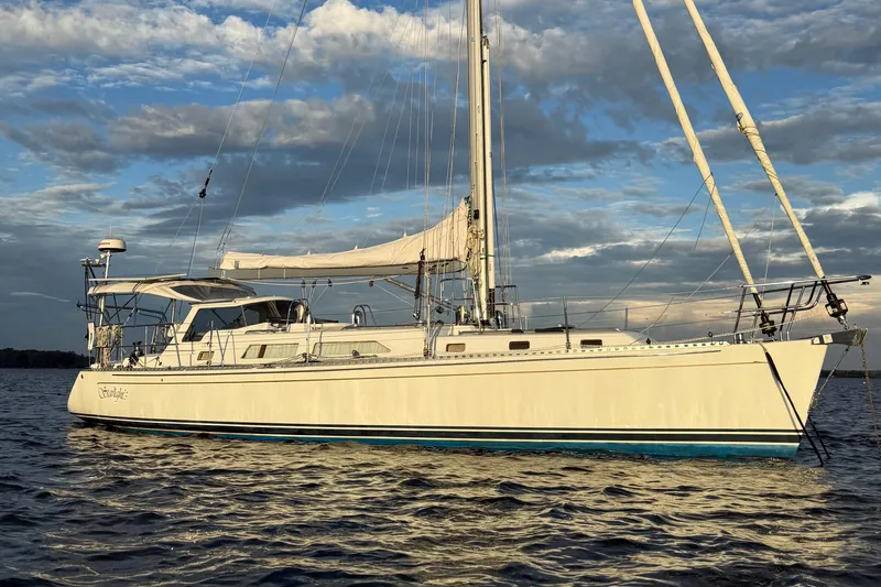 Starlight Yacht Photos Pics Sailing yacht Outbound 46, 2016 model, on calm waters under a cloudy sky.