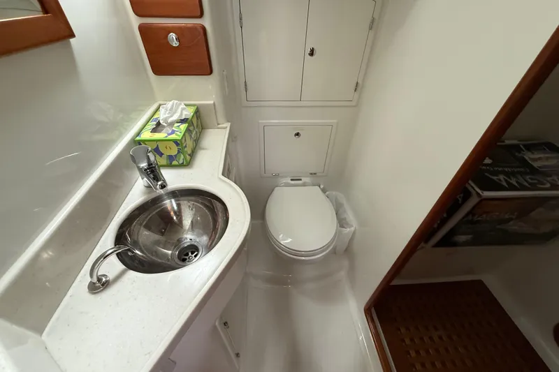 Starlight Yacht Photos Pics Compact bathroom in 2016 Outbound 46 yacht with sink, toilet, and storage cabinets.