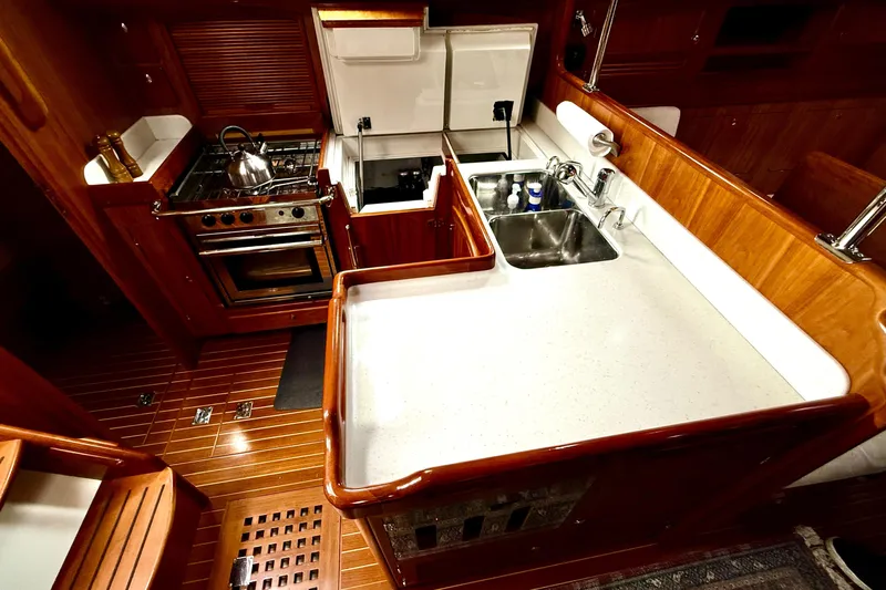 Starlight Yacht Photos Pics Luxurious 2016 Outbound 46 yacht kitchen with stove, sink, and wooden cabinetry.