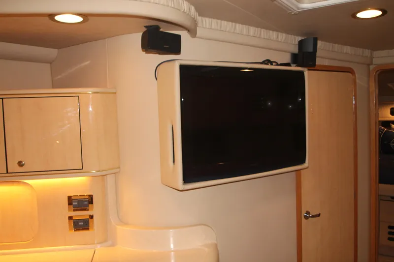 Broke R Yacht Photos Pics Interior of 1999 Sea Ray 460 Sundancer with mounted TV and wooden cabinetry.