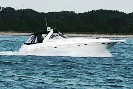 Broke R Yacht Photos Pics 1999 Sea Ray 460 Sundancer cruising on open water near a forested shoreline.