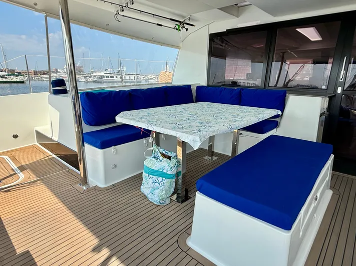 Confetti Yacht Photos Pics Spacious outdoor seating area on 2016 Fountaine Pajot SABA 50 catamaran with blue cushions.