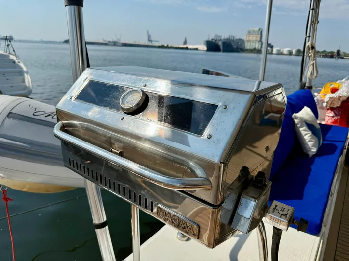 Confetti Yacht Photos Pics Stainless steel grill on a 2016 Fountaine Pajot SABA 50 yacht, docked by the water.