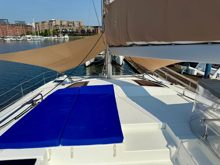 Confetti Yacht Photos Pics 2016 Fountaine Pajot SABA 50 catamaran with blue sunbeds and tan sails docked at marina.