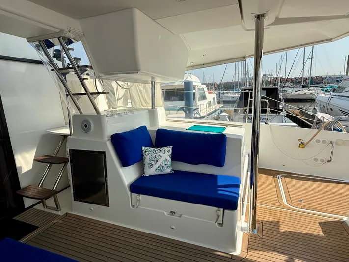Confetti Yacht Photos Pics Luxurious 2016 Fountaine Pajot SABA 50 yacht interior with blue seating and wooden deck.