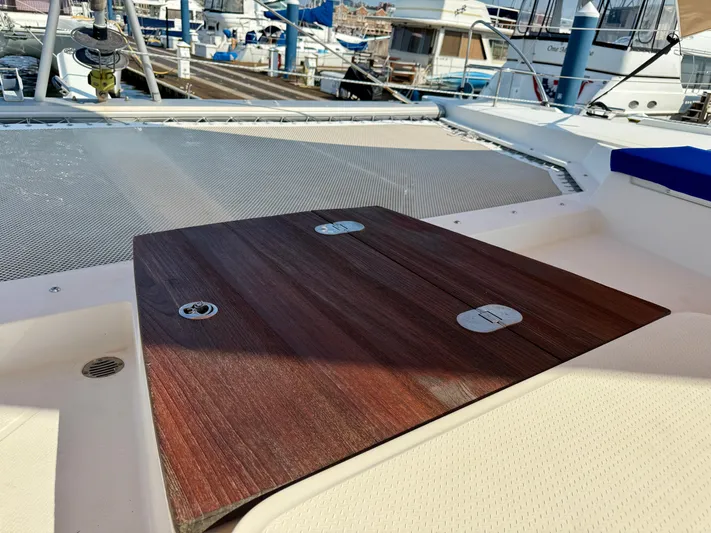 Confetti Yacht Photos Pics Deck of 2016 Fountaine Pajot SABA 50 catamaran with wooden table and netting.