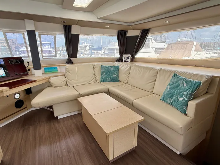 Confetti Yacht Photos Pics Luxurious interior of 2016 Fountaine Pajot SABA 50 yacht with beige seating and teal cushions.