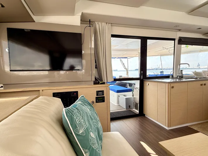 Confetti Yacht Photos Pics Interior of 2016 Fountaine Pajot SABA 50 yacht with TV, kitchen, and outdoor view.