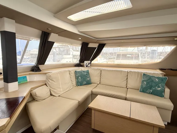 Confetti Yacht Photos Pics Luxurious interior of 2016 Fountaine Pajot SABA 50 yacht with beige seating and teal cushions.