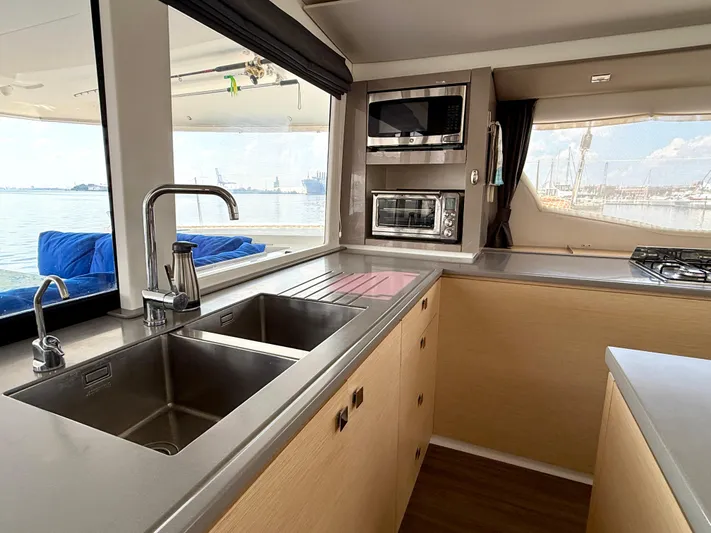 Confetti Yacht Photos Pics Modern kitchen interior of 2016 Fountaine Pajot SABA 50 catamaran with ocean view.