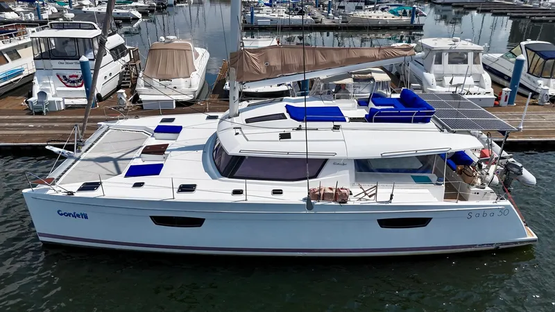 Confetti Yacht Photos Pics 2016 Fountaine Pajot SABA 50 catamaran docked at marina, featuring solar panels and blue seating.
