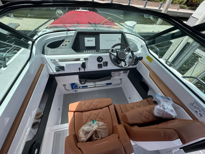  Yacht Photos Pics 2022 Axopar 28 T-top Aft Cabin Brabus Trim cockpit with modern controls and brown seating.