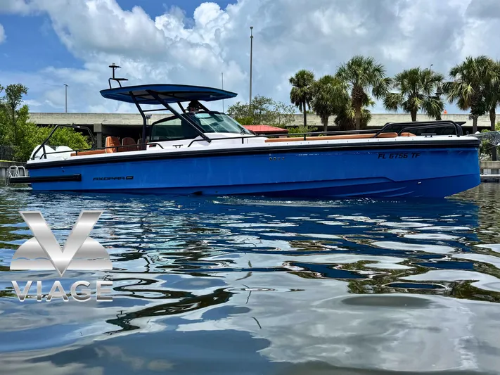  Yacht Photos Pics 2022 Axopar 28 T-top Aft Cabin Brabus Trim boat on water, palm trees in background.