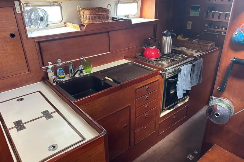 Prism Yacht Photos Pics Cozy 1984 Oyster 435 yacht kitchen with wooden cabinetry and modern appliances.