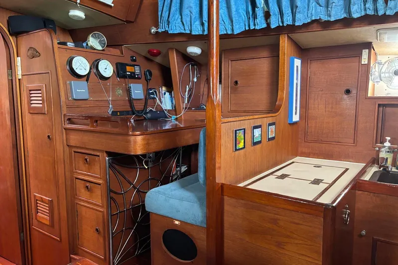 Prism Yacht Photos Pics Interior of 1984 Oyster 435 yacht with navigation station and wooden cabinetry.