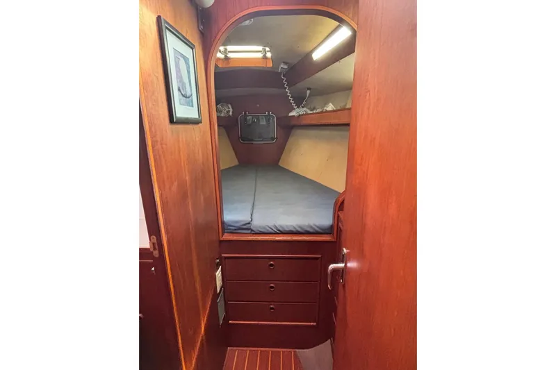 Prism Yacht Photos Pics 1984 Oyster 435 yacht cabin with wooden interior and cozy sleeping area.
