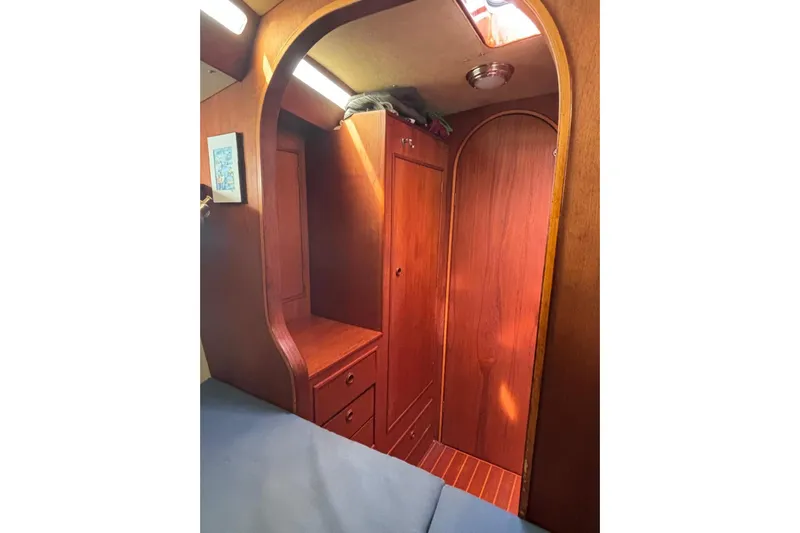 Prism Yacht Photos Pics Cozy wooden interior of 1984 Oyster 435 sailboat cabin with storage and lighting.