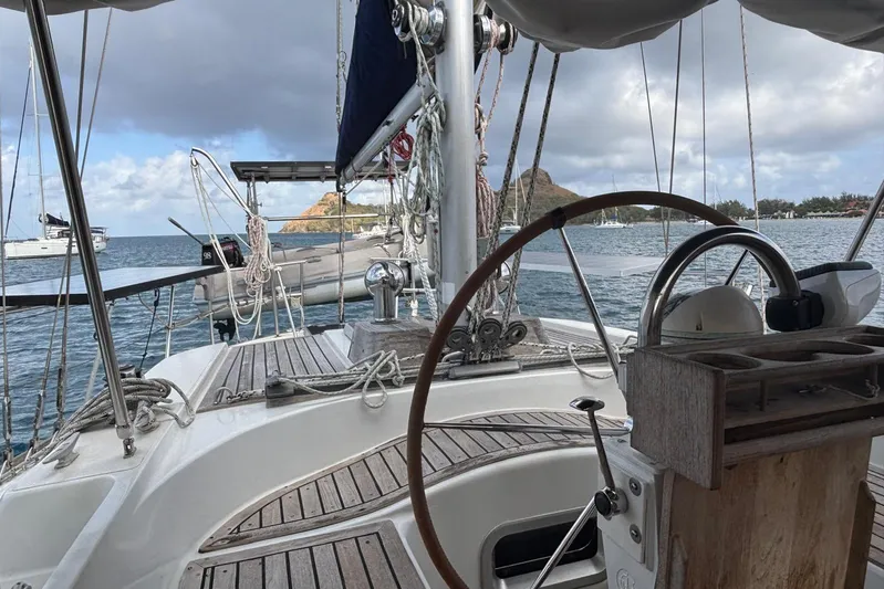 Prism Yacht Photos Pics 1984 Oyster 435 sailboat cockpit with scenic ocean view and distant hills.