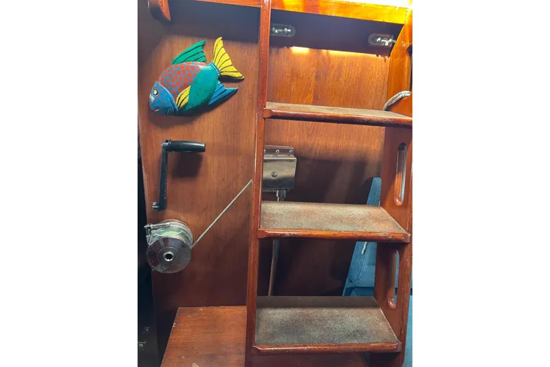 Prism Yacht Photos Pics Wooden interior of 1984 Oyster 435 yacht with colorful fish decor and steps.