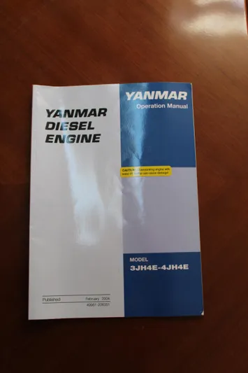 Coyote Yacht Photos Pics Yanmar diesel engine manual for model 3JH4E-4JH4E on wooden surface.