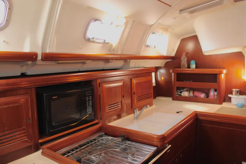 Coyote Yacht Photos Pics Interior of 2004 Beneteau Oceanis Clipper 423 yacht kitchen with wood cabinetry and appliances.