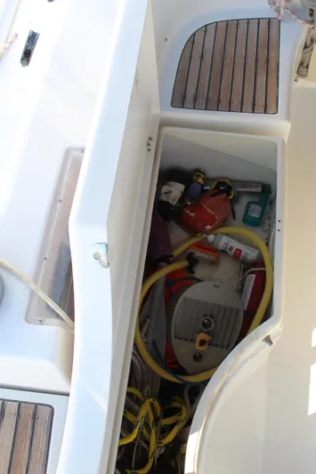 Coyote Yacht Photos Pics Storage compartment on a 2004 Beneteau Oceanis Clipper 423 sailboat, containing various tools and equipment.
