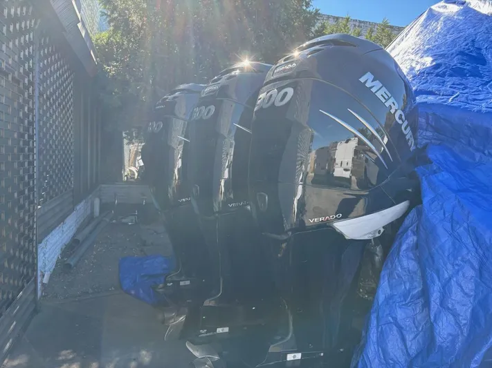  Yacht Photos Pics Four Mercury Verado outboard engines lined up, partially covered, in outdoor setting.