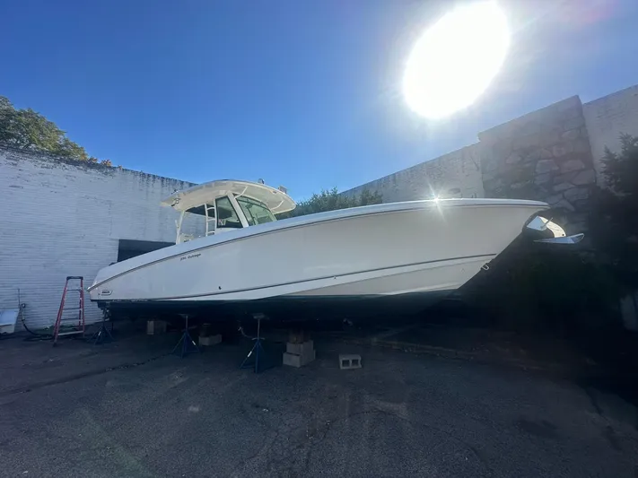  Yacht Photos Pics 2016 Boston Whaler 350 Outrage boat on stands, sunlit background.