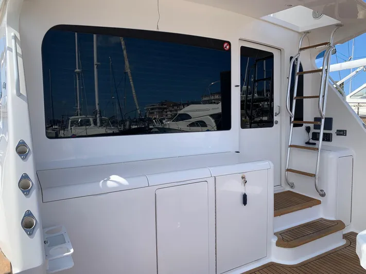  Yacht Photos Pics 2007 Viking 52 yacht deck with stairs, window, and storage cabinets.