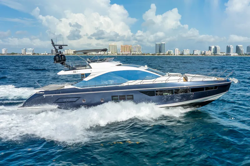  Yacht Photos Pics 2019 Azimut S7 yacht cruising on ocean with city skyline in background.