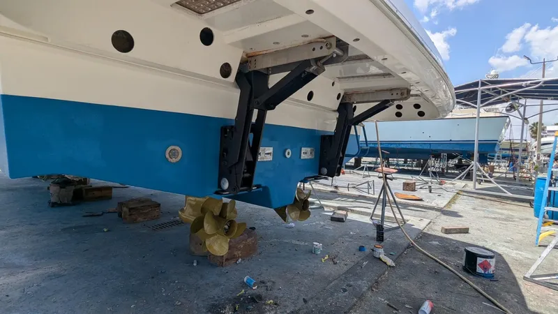 Ain't Settlin! Yacht Photos Pics 2013 Prestige 550 Flybridge yacht under maintenance, showcasing propellers and hull in a shipyard.