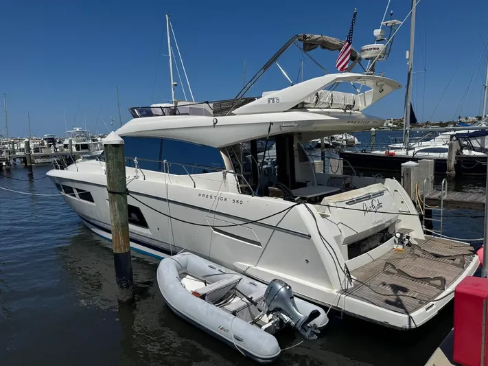 Ain't Settlin! Yacht Photos Pics 2013 Prestige 550 Flybridge yacht docked with inflatable boat, clear sky background.