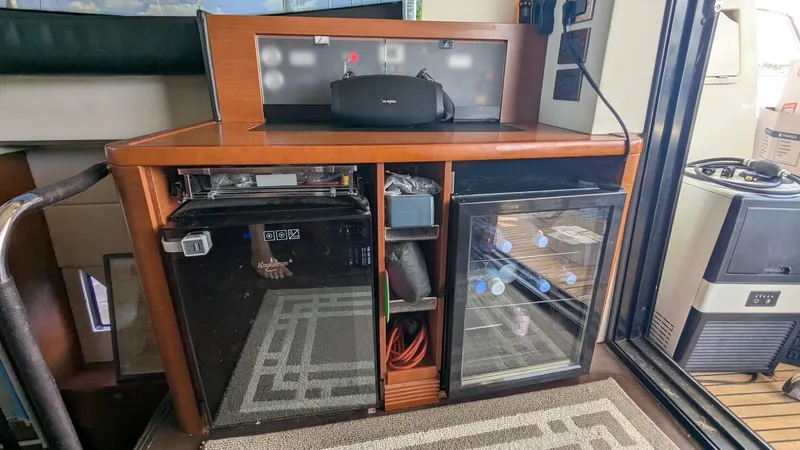 Ain't Settlin! Yacht Photos Pics 2013 Prestige 550 Flybridge interior with mini fridge and storage cabinets.