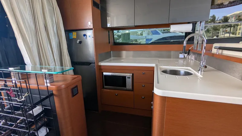 Ain't Settlin! Yacht Photos Pics Modern kitchen interior on 2013 Prestige 550 Flybridge yacht with sink, microwave, and fridge.
