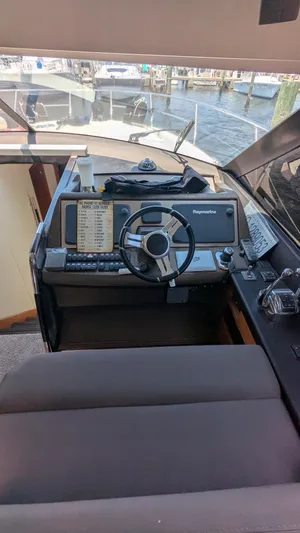 Ain't Settlin! Yacht Photos Pics Helm of 2013 Prestige 550 Flybridge yacht with steering wheel and control panel.