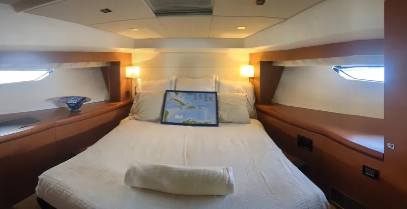 Ain't Settlin! Yacht Photos Pics Luxurious cabin interior of 2013 Prestige 550 Flybridge yacht with cozy bed and ambient lighting.