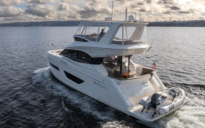 Carving Time Yacht Photos Pics 2019 Carver C52 Command Bridge yacht cruising on a calm lake under cloudy skies.