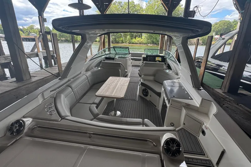  Yacht Photos Pics 2020 Sea Ray SLX 350 boat interior with seating, table, and helm under a dock.
