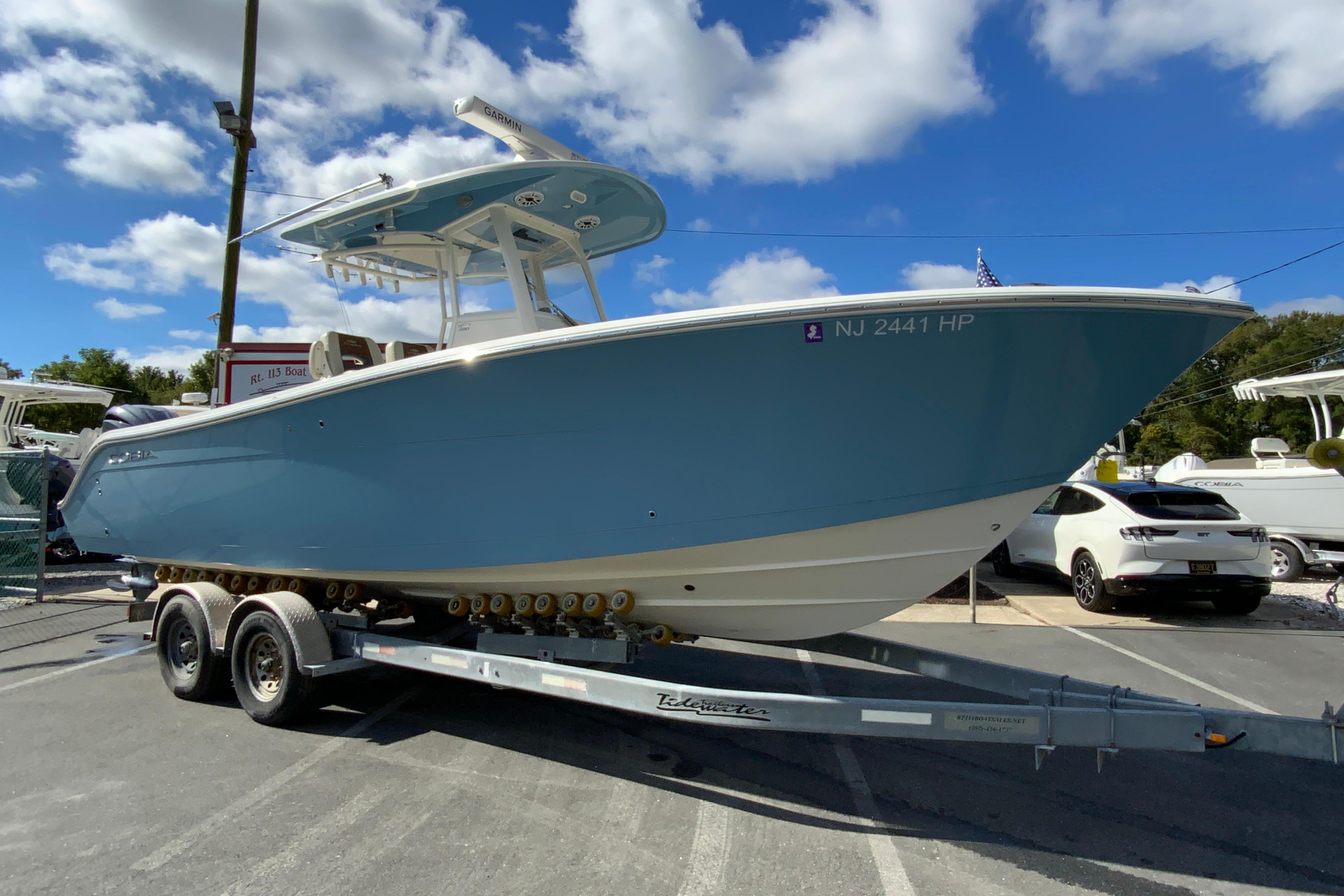 2021 Cobia 280 Center Console boat on trailer under blue sky.