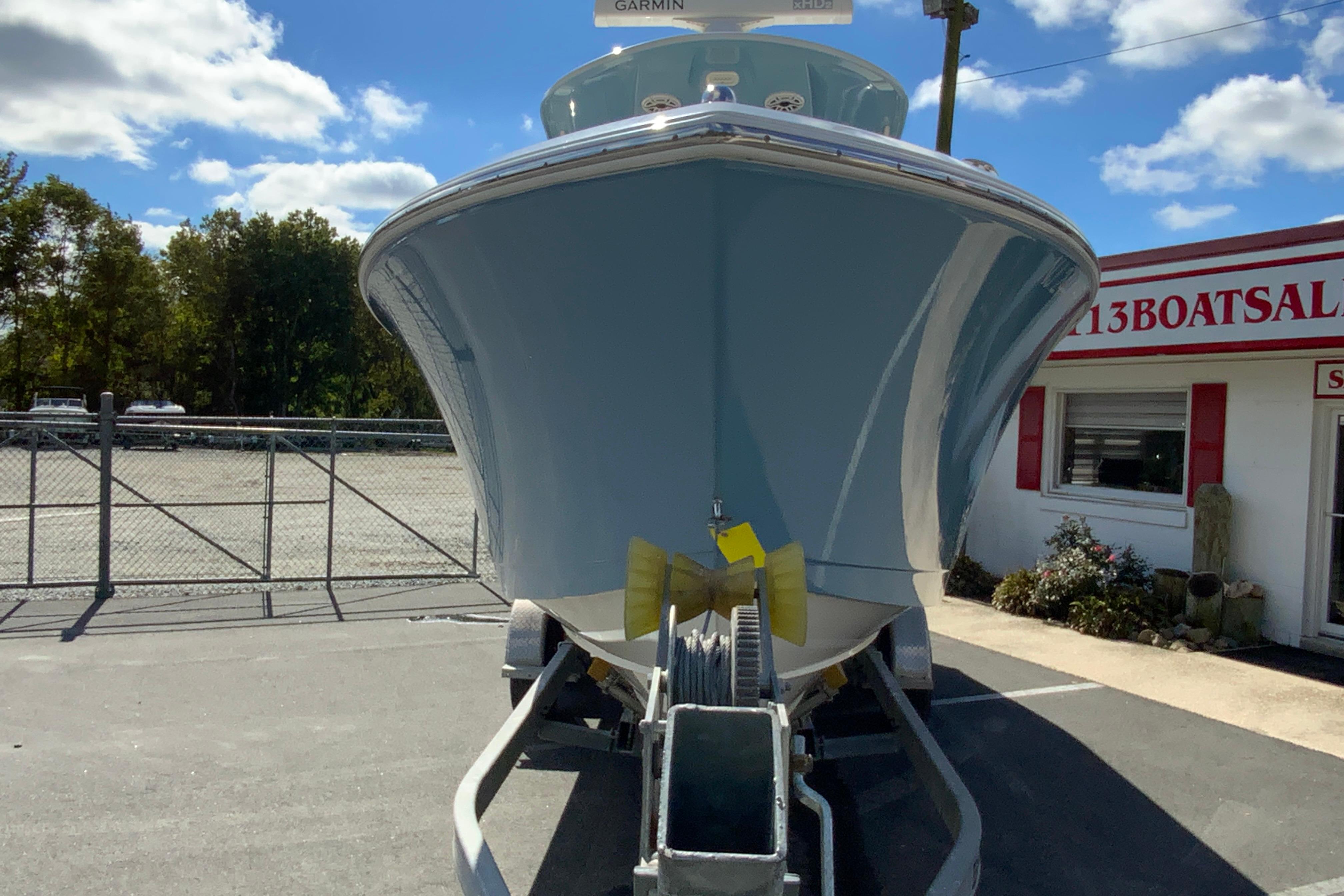 2021 Cobia 280 Center Console boat on trailer at dealership under blue sky.