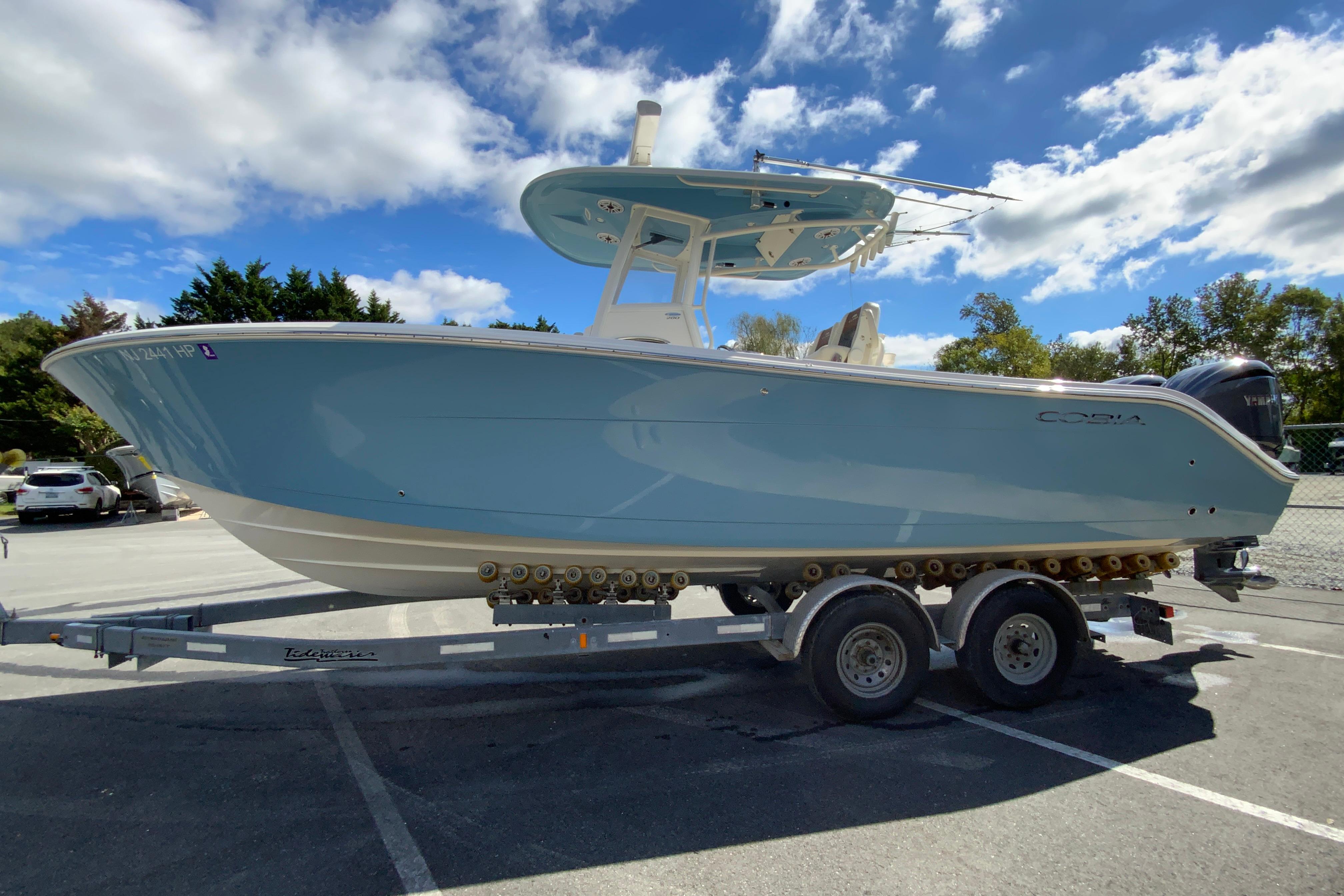 2021 Cobia 280 Center Console boat on trailer under blue sky.