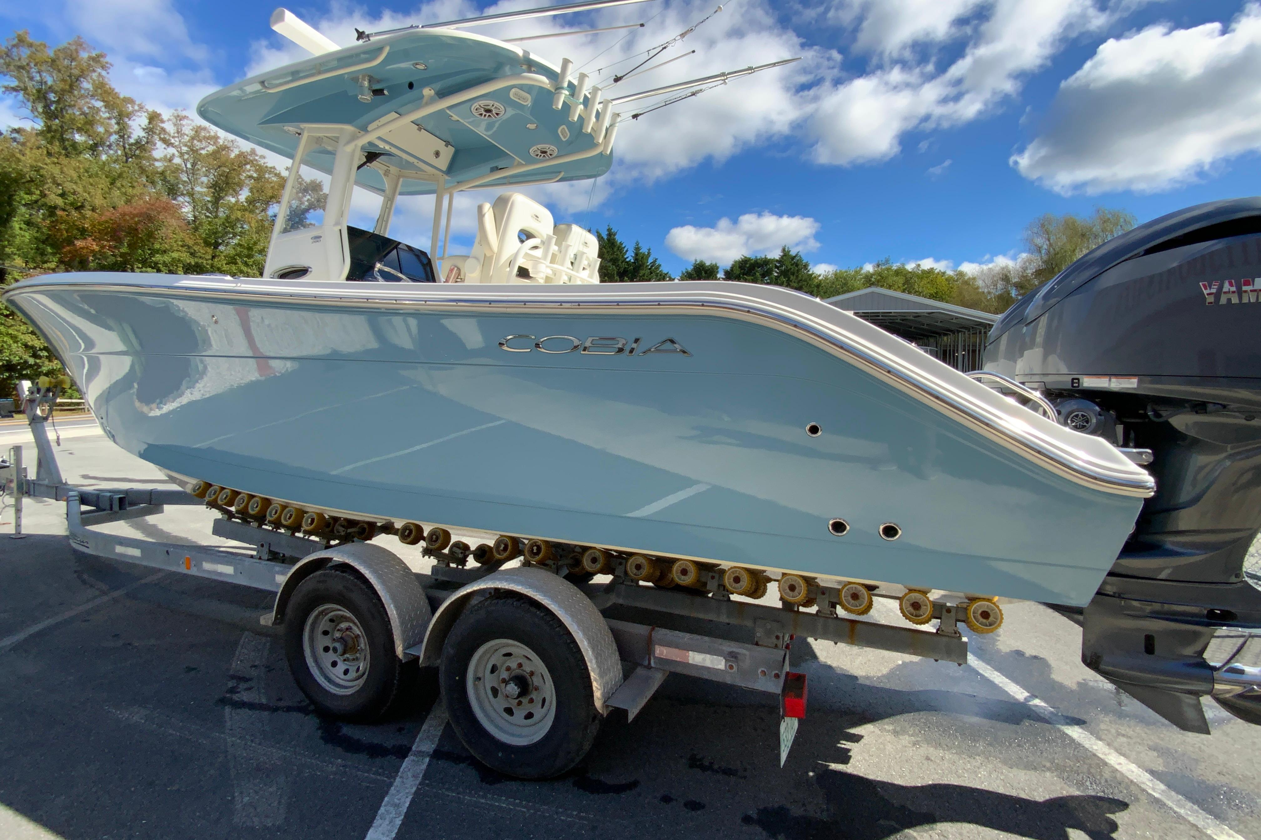 2021 Cobia 280 Center Console boat on trailer under blue sky.