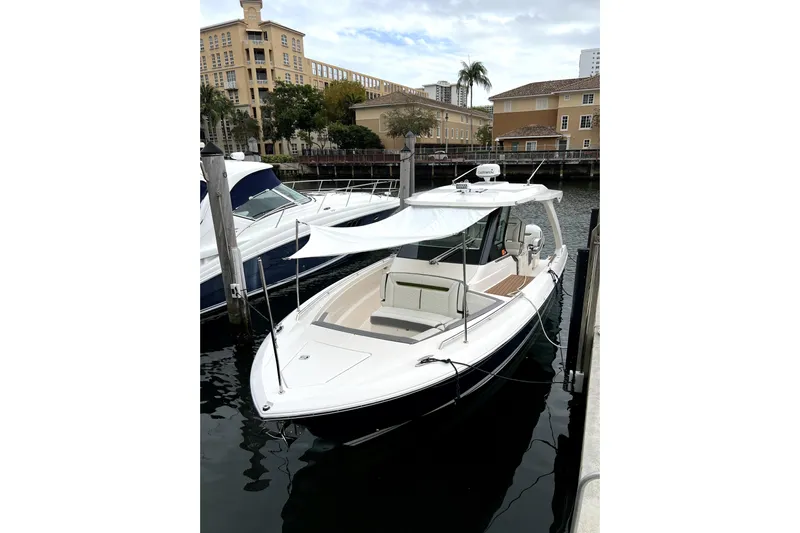  Yacht Photos Pics 2019 Tiara Sport 34 LS boat docked in a marina, featuring sleek design and sunshade.