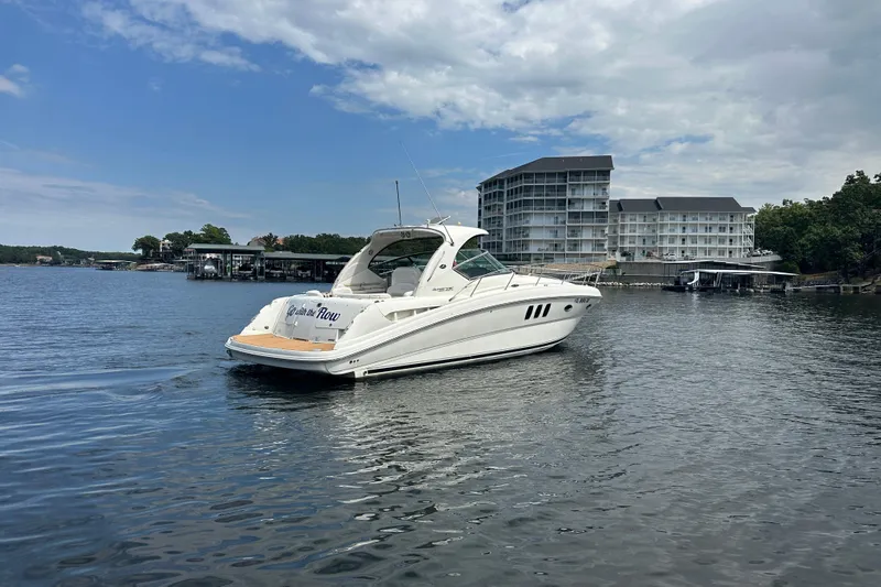  Yacht Photos Pics 2010 Sea Ray 390 Sundancer yacht on a calm lake near modern buildings.