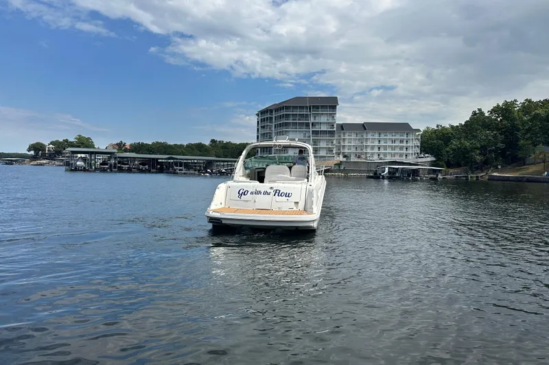  Yacht Photos Pics 2010 Sea Ray 390 Sundancer boat on a lake near a marina and buildings.