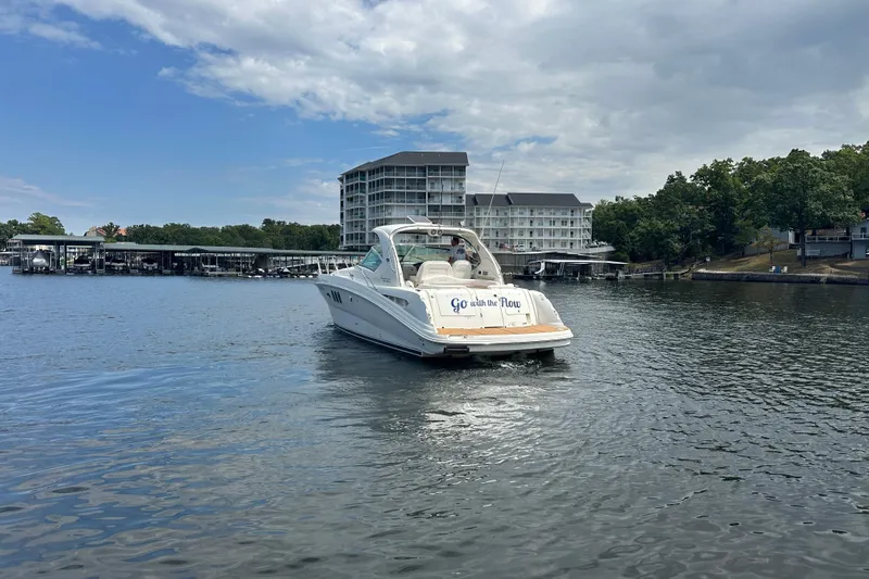  Yacht Photos Pics 2010 Sea Ray 390 Sundancer yacht cruising near marina and waterfront buildings.