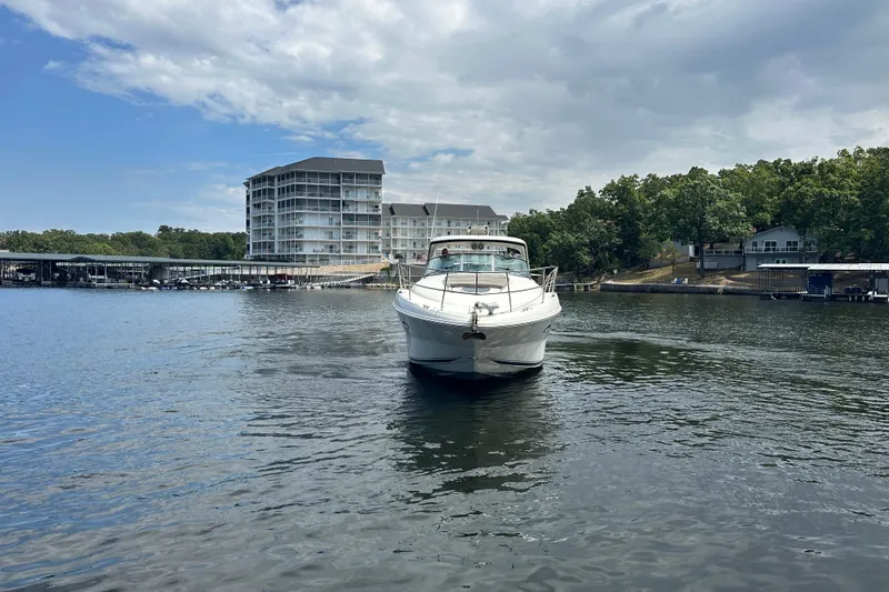  Yacht Photos Pics 2010 Sea Ray 390 Sundancer yacht on a serene lake with buildings and trees.