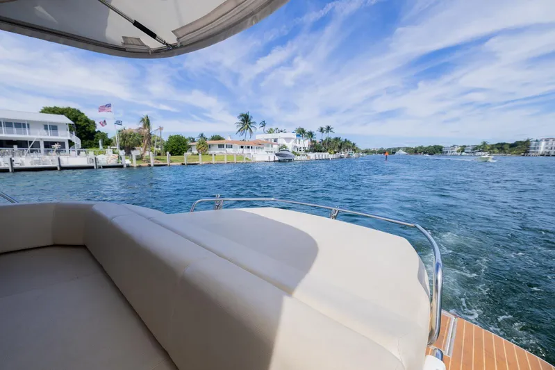She's Royal Yacht Photos Pics 2014 Cranchi M 44 HT yacht cruising near waterfront homes under a blue sky.
